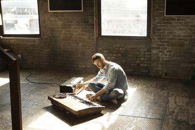 Homem tocando teclado no estúdio