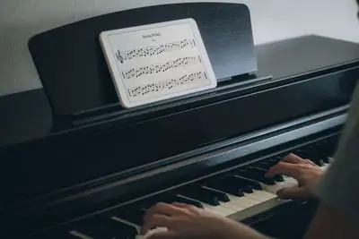 Músico tocando piano com notação no tablet pc