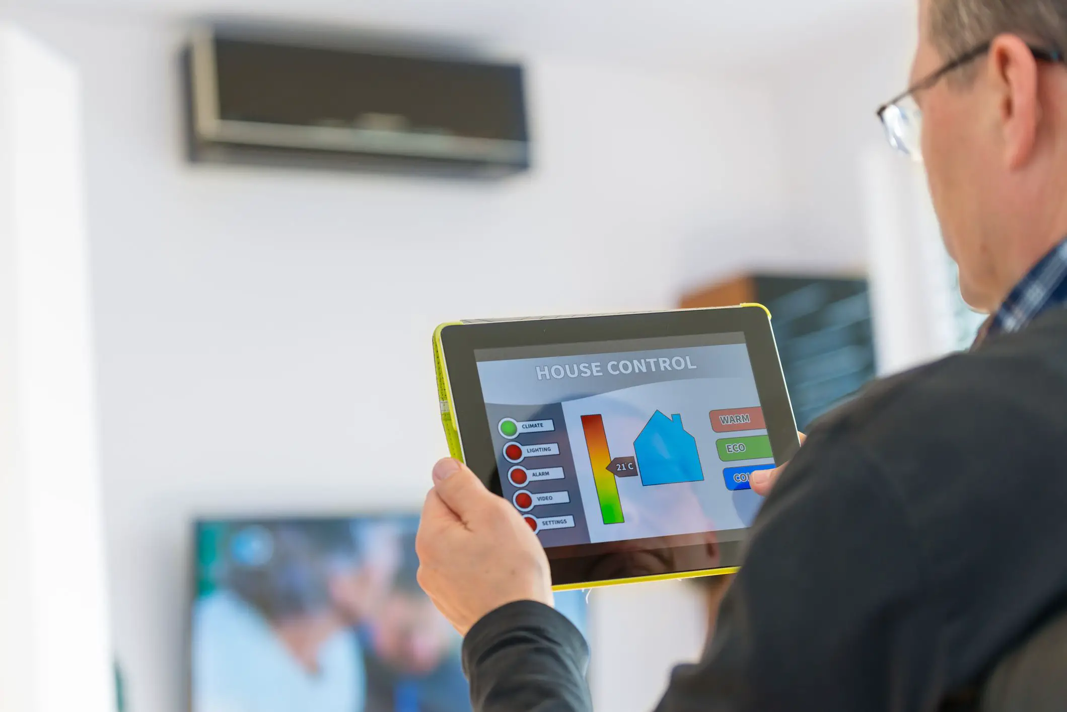 Proprietário usando um tablet para controlar o ar condicionado inteligente em sua casa