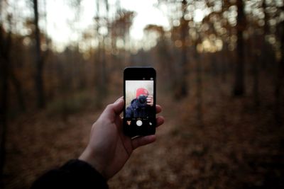 Um fotógrafo tirando uma selfie com um iPhone.