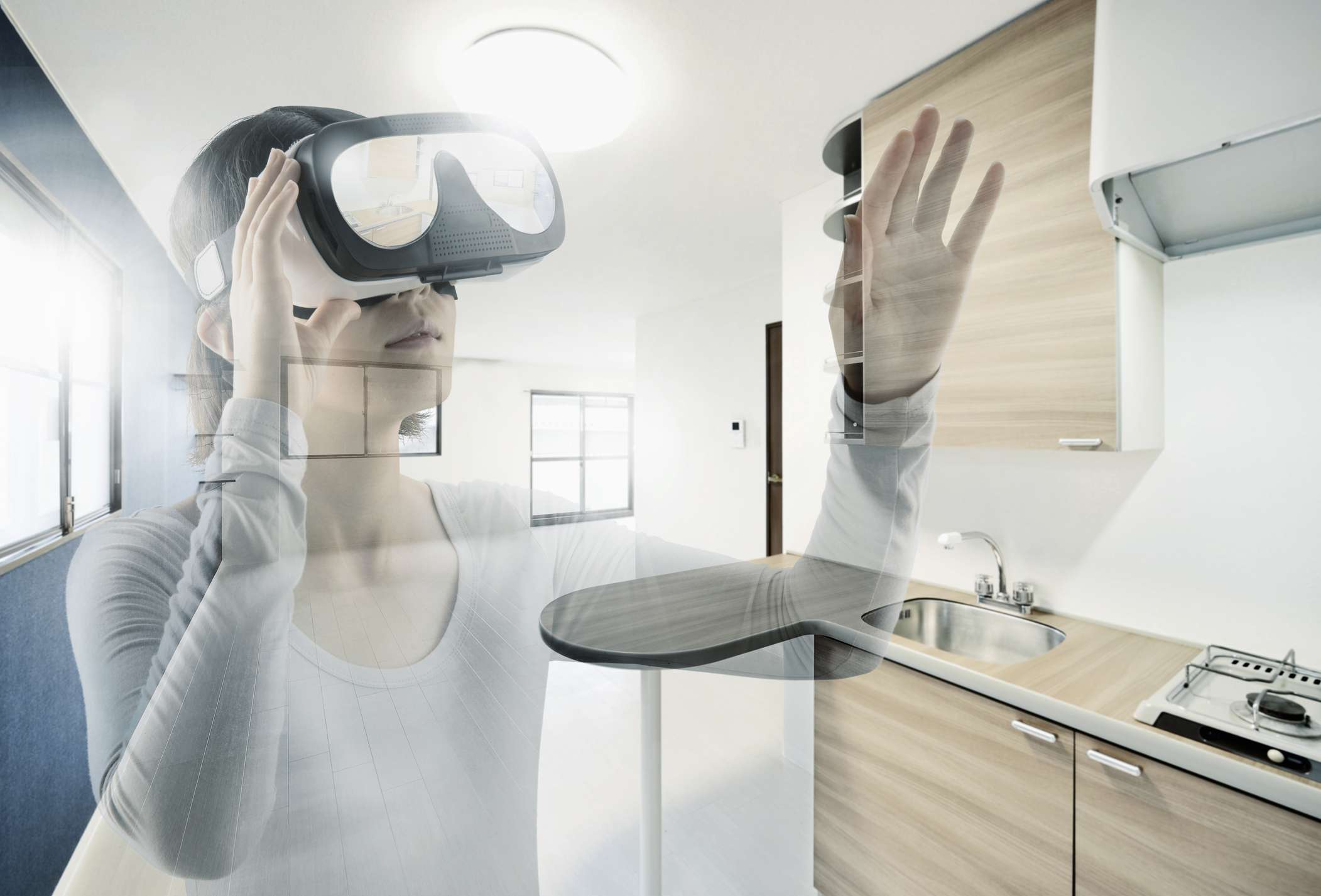 Alguém usando um fone de ouvido de realidade virtual com um apartamento vazio sobreposto na imagem. 
