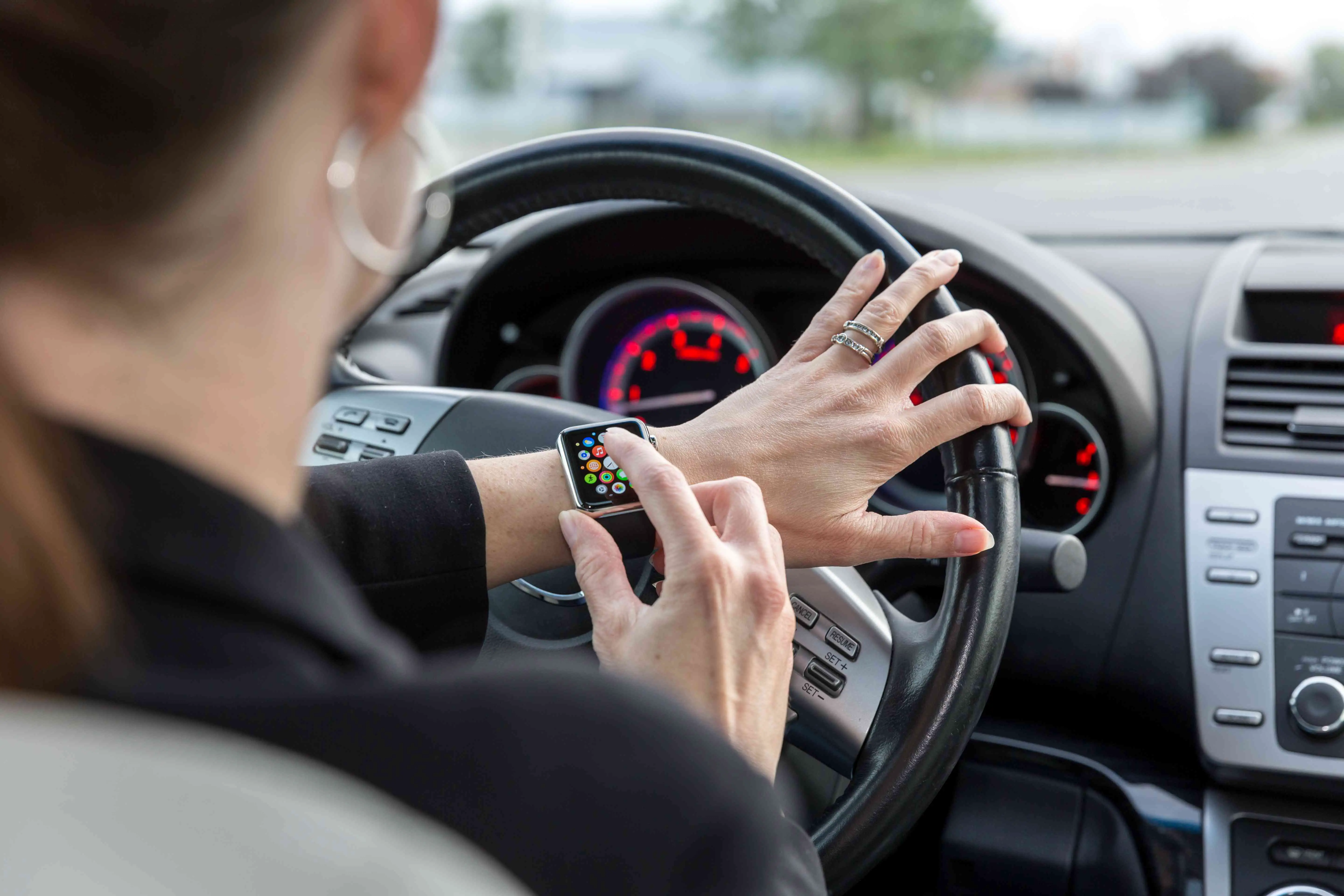 Mulher usando Apple Watch enquanto dirige um carro