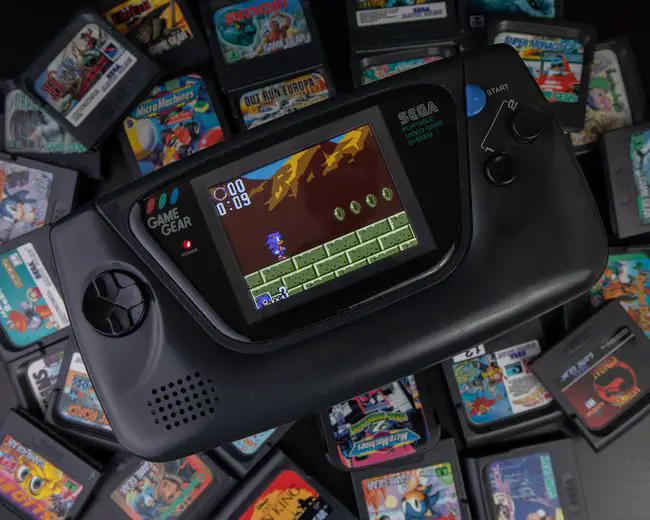 Um console da Sega cercado por cartuchos de jogos.
