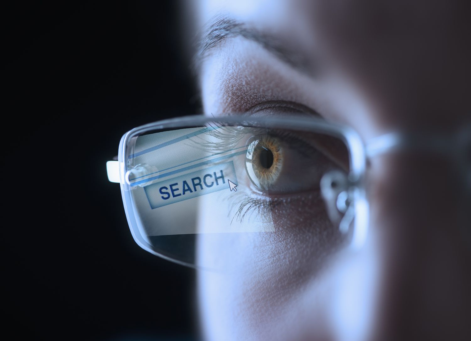Coseup de um olho humano, usando óculos com um botão Pesquisar refletido na lente.
