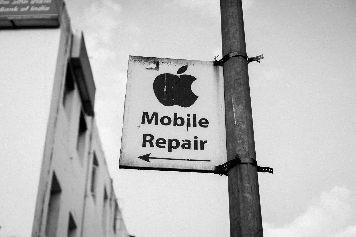 Placa de rua que diz "Mobile Conserto" sob o logotipo da Apple