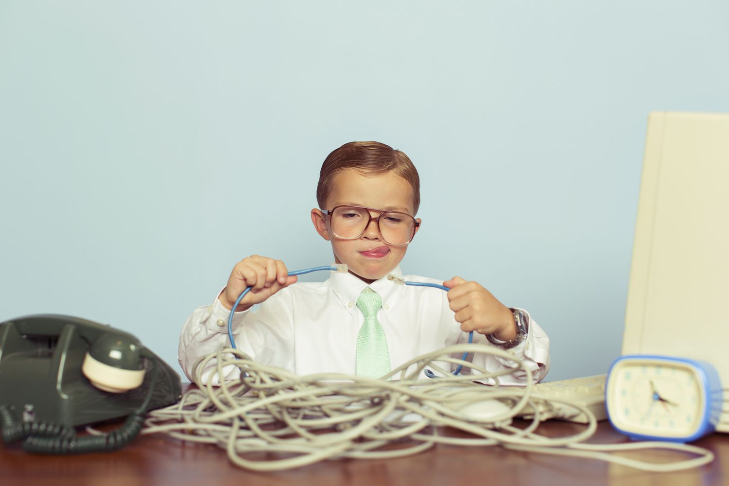garoto trabalhando com uma grande pilha de cabos de internet emaranhados em sua mesa