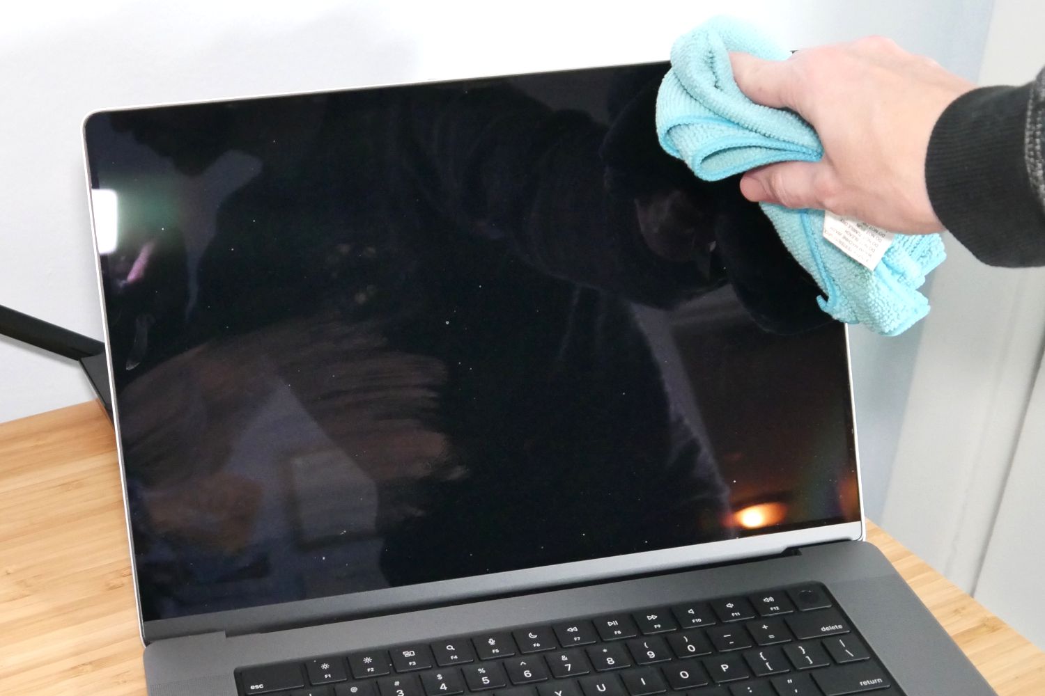 Uma tela do MacBook Pro limpa com um pano de microfibra. 
