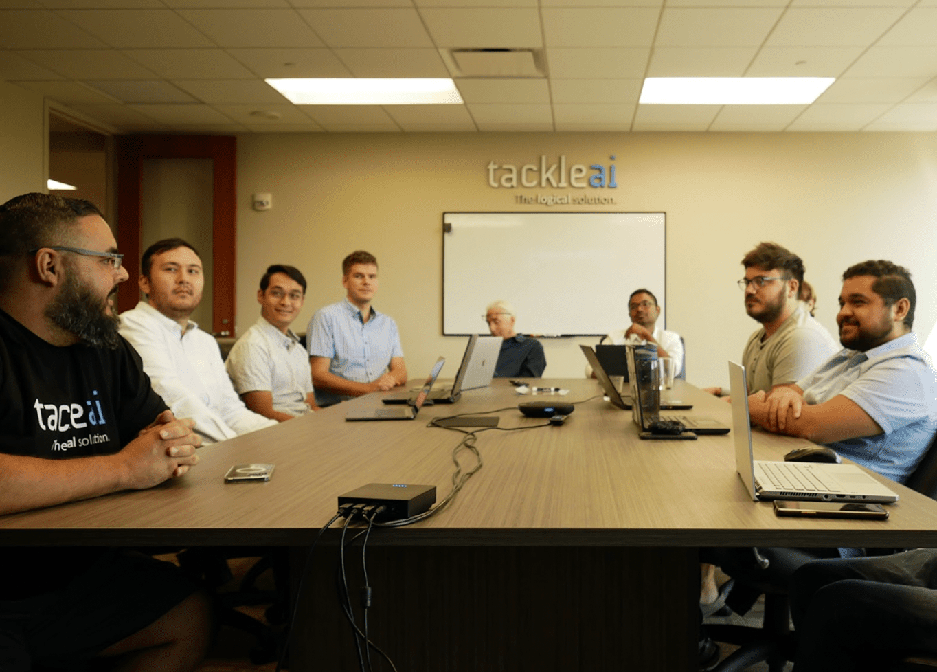 O CEO da TackleAI, Sergio Suarez, se encontra com sua equipe em uma sala de reuniões