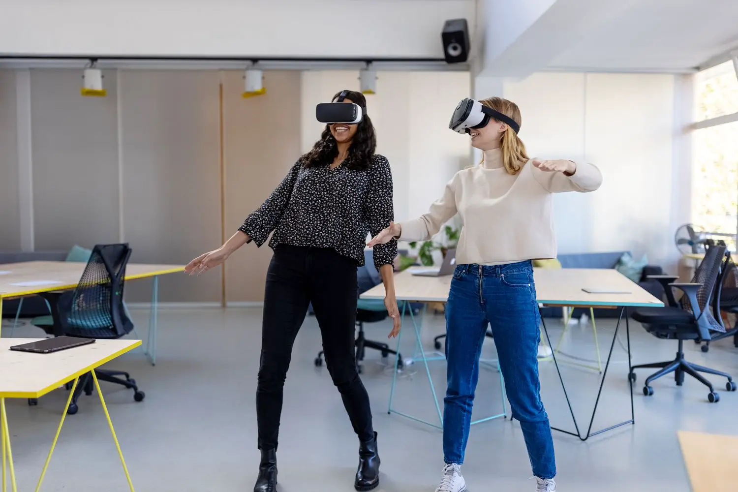 Duas pessoas usando headsets de realidade virtual em um ambiente de escritório.